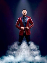 a man in a red jacket standing on top of smoke