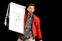a man holding up a white board with a drawing on it