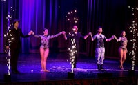 a group of dancers on stage with sparklers